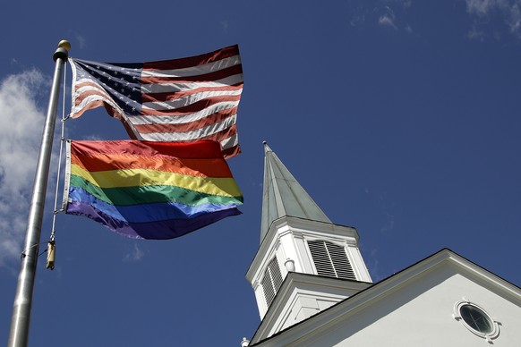 FILE - In this April 19, 2019, file photo, a gay pride rainbow flag flies along with the U.S. flag in front of the Asbury United Methodist Church in Prairie Village, Kan., United Methodist Church lead ...