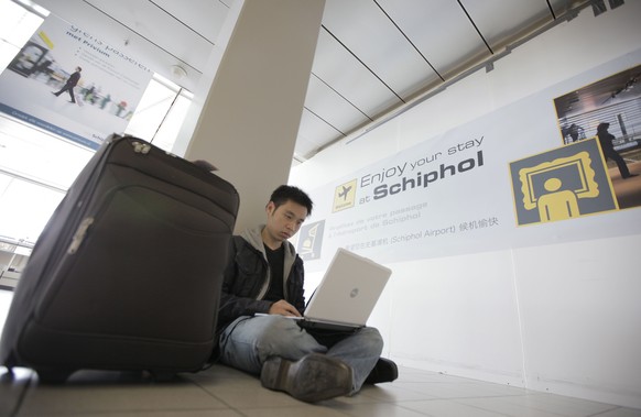 FILE - In this Saturday, April 17, 2010, file photo, a traveler from Malaysia uses his laptop computer at Schiphol Airport, Amsterdam, Netherlands. International air travelers might soon rediscover ma ...