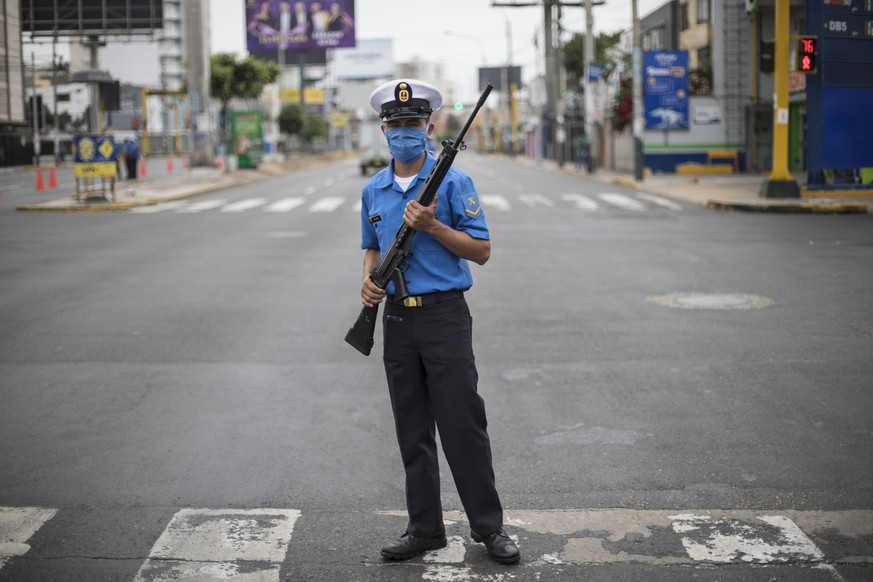 A Marine wearing a protective mask as a precaution against the spread of the new coronavirus stands guard to keep the streets cleared, in Lima, Peru, Tuesday, March 17, 2020. Peru&#039;s President Mar ...