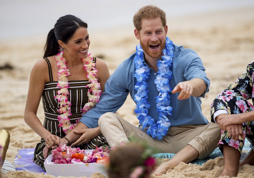 FILE - In this Friday, Oct. 19, 2018 file photo Britain&#039;s Prince Harry and Meghan, Duchess of Sussex meet with a local surfing community group, known as OneWave, raising awareness for mental heal ...