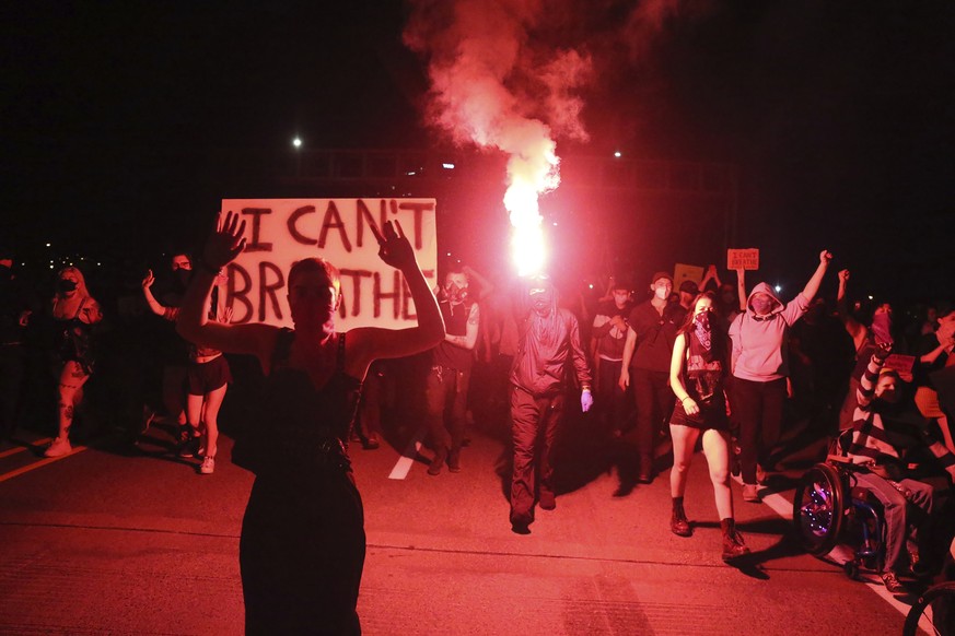 In this May 29, 2020, photo, Portlanders march with flares from the George Floyd vigil at Peninsula Park towards the Justice Center downtown in Portland, Oregon. Protests have been erupting all over t ...