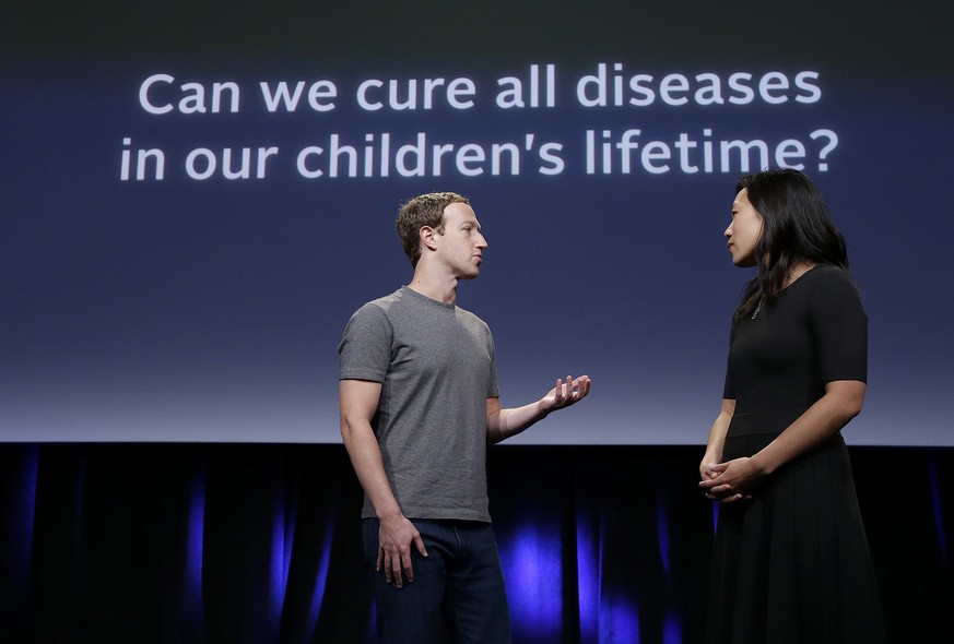 In this Tuesday, Sept. 20, 2016, photo, Facebook CEO Mark Zuckerberg speaks with his wife, Priscilla Chan, as they prepare for a presentation in San Francisco. Zuckerberg and Chan have a new lofty goa ...