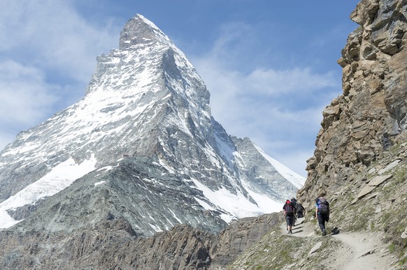 epa04322639 Hikers walk toward the Matterhorn Mountain in Zermatt, Switzerland, 19 July 2014. The same day the &#039;Base Camp Matterhorn&#039; opened its tent camp, which until 15 September 2014 serv ...