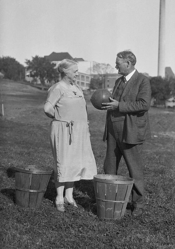 (Original Caption) Originators of Basketball Discuss the Game. Lawrence, Kansas: Photo shows Mr. and Mrs. James Naismith, discussing the game of basketball of which they are the originators. The peach ...