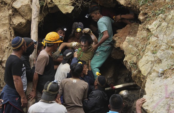 FILE - In this Feb. 27, 2019, file photo, rescuers carry a survivor from inside a collapsed mine in Bolaang Mongondow, North Sulawesi, Indonesia. Indonesian authorities say they’re not certain how man ...