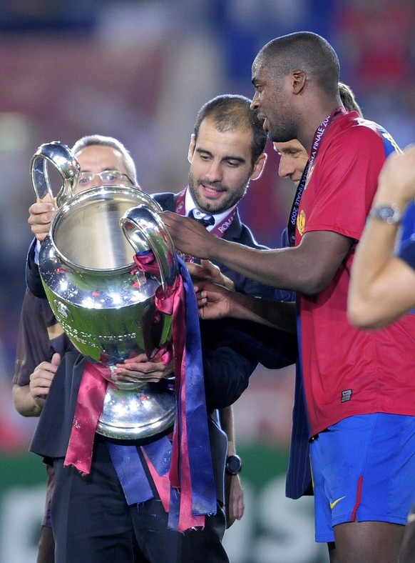 Barcelona coach Pep Guardiola holds the trophy at the end of the UEFA Champions League final soccer match between Manchester United and Barcelona in Rome, Wednesday May 27, 2009. Barcelona won 2-0. (A ...
