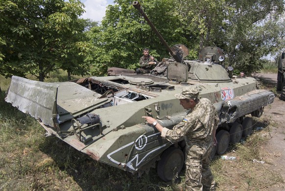 epa04851968 Volunteers of the Ukrainian &#039;Donbass&#039; battalion examine a damaged armored military vehicle, which they claim belonged to pro-Russian separatists and recently captured by &#039;Do ...