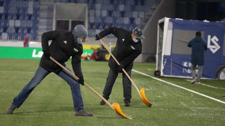 Lausanne&#039;s staff remove ice in pitch, prior the Super League soccer match of Swiss Championship between FC Lausanne-Sport and Servette FC, at the Stade de la Tuiliere, in Geneva, Switzerland, Sat ...