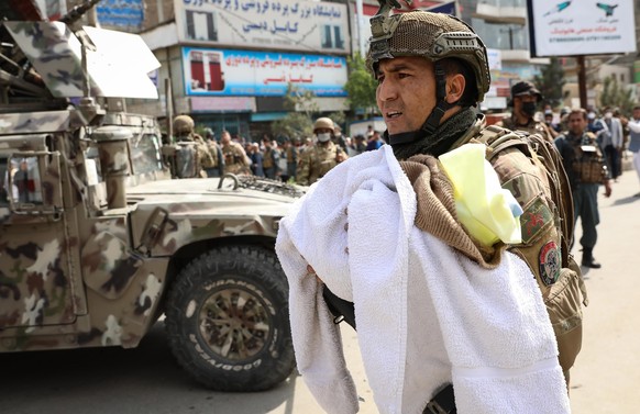 epa08416914 An Afghan soldier shifts a baby at the scene of an attack at MSF (Doctors without Borders) hospital, in Kabul, Afghanistan, 12 May 2020. According to reports, at least 12 people were kille ...