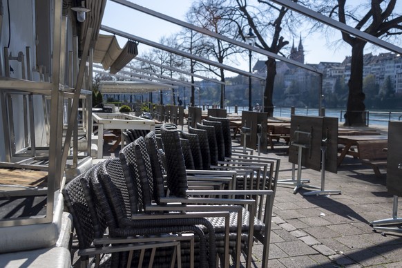 Gartentische, Stuehle und Baenke vor geschlossenen Restaurants am Kleinbasler Rheinufer in Basel am Mittwoch, 25. Maerz 2020. (KEYSTONE/Georgios Kefalas)
