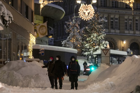 Passanten sind bei starkem Schneefall unterwegs in St. Moritz, am Samstag, 5. Dezember 2020. (KEYSTONE/Alexandra Wey)