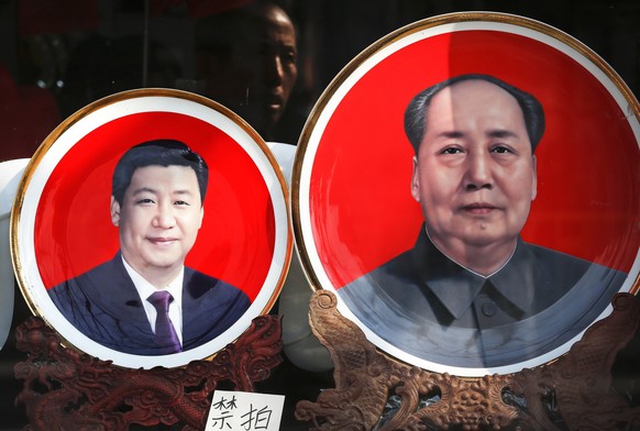 FILE - In this March 1, 2016 file photo, souvenir plates bearing images of Chinese President Xi Jinping, left, and late Chinese leader Mao Zedong are displayed at a shop near Tiananmen Square in Beiji ...