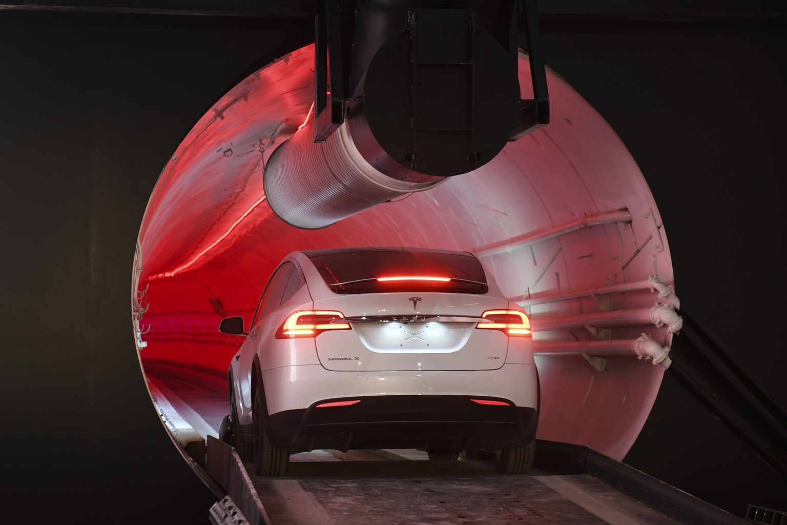 A modified Tesla Model X drives in the tunnel entrance before an unveiling event for the Boring Co. Hawthorne test tunnel in Hawthorne, Calif., Tuesday, Dec. 18, 2018. Elon Musk unveiled his undergrou ...