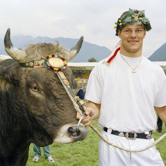 Thomas Sutter posiert als Schwingerkoenig mit einem jungen Stier, seinem Preis am eidgenoessischen Schwingfest am 14. August 1995 in Chur. (KEYSTONE/Str) === ===