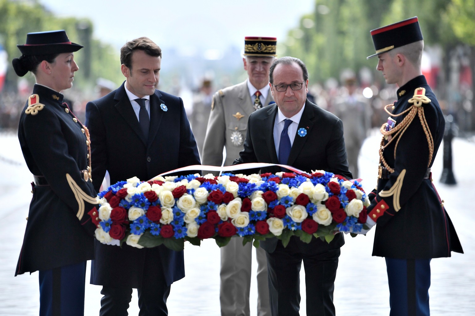 French President-elect Emmanuel Macron, second left, and outgoing President Francois Hollande lay a wreath of flowers at the tomb of the Unknown Soldier during a ceremony to mark the end of World War  ...