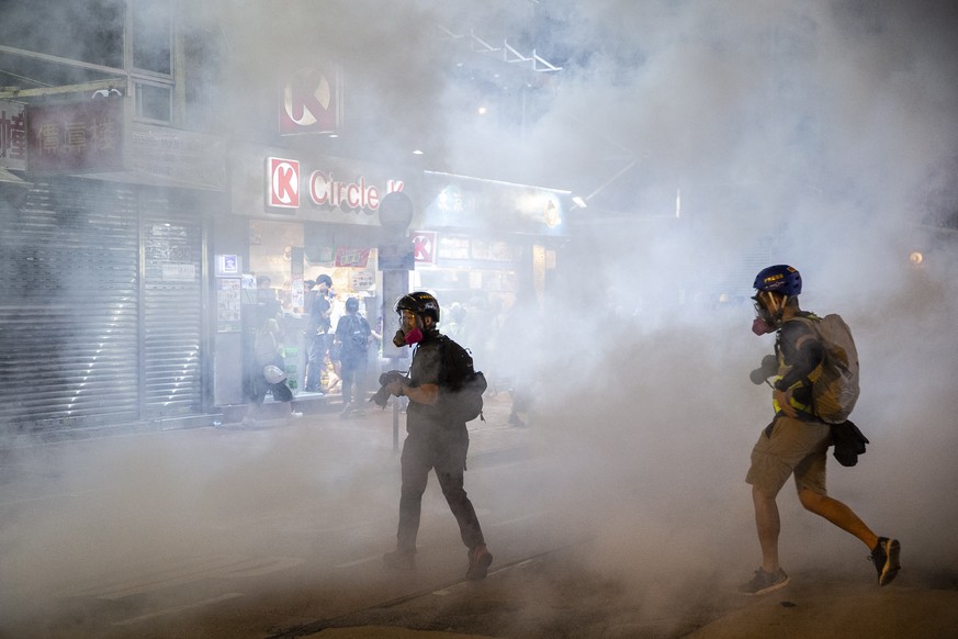 epa07859779 Members of the media photograph tear gas fired by riot police to disperse protesters in Yuen Long district, Hong Kong, China, 21 September 2019. Hong Kong has entered its fourth month of m ...