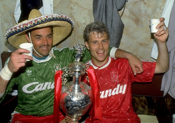 1 May 1990: Bruce Grobbelaar (left) and Glenn Hysen of Liverpool celebrate with the trophy after the Barclays League Division One match against Derby County at Anfield in Liverpool, England. Liverpool ...