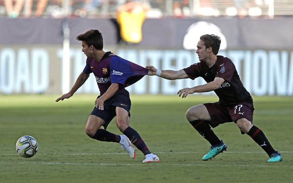 epa06928186 A.C. Milan middle fielder Halilovic Alen (R) grabs the jersey of FC Barcelona middle fielder Ricky Puig (L) during the International Champions Cup match between A.C. Milan and FC Barcelona ...
