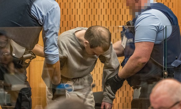 epa08626152 Guards handle Brenton Tarrant (C) during day three sentencing at the High Court in Christchurch, New Zealand, 26 August 2020. Australian white supremacist Brenton Tarrant will be sentenced ...
