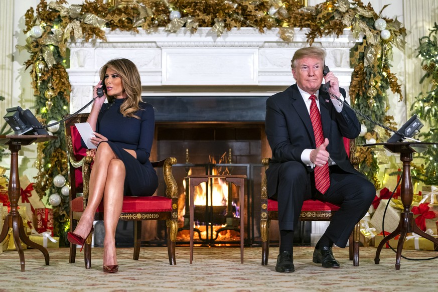 epa07247880 US President Donald J. Trump (R) and First Lady Melania (L) speak with children who are calling the NORAD (North American Aerospace Defense Command) Santa tracker in the State Dining Room  ...
