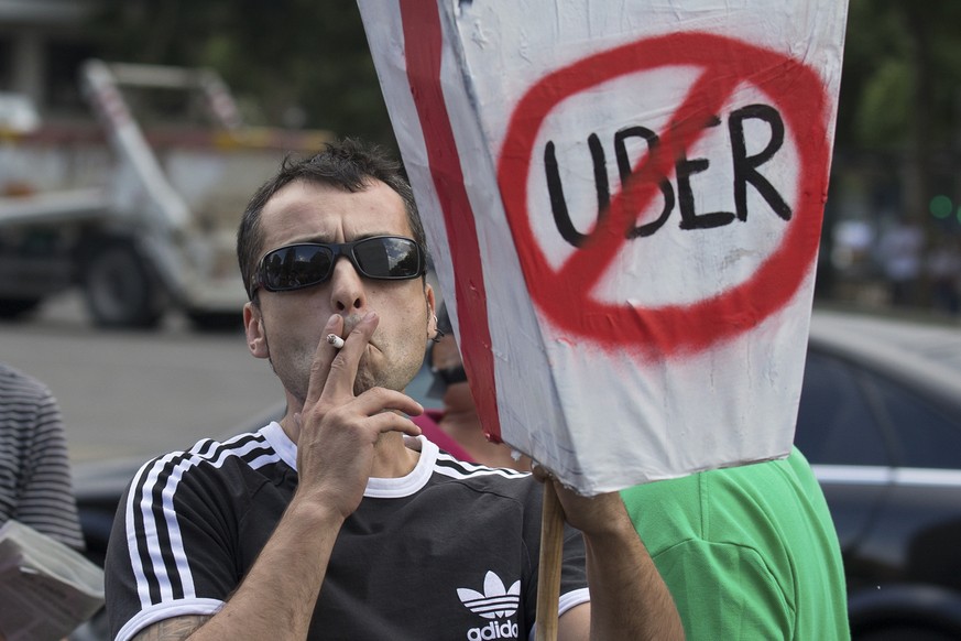 In this photo taken on June 11, 2014, a taxi driver protests against Uber during a 24 hour taxi strike in Madrid, Spain. In a statement Saturday July 22, 2017, the city of Madrid has asked Spain&#039; ...