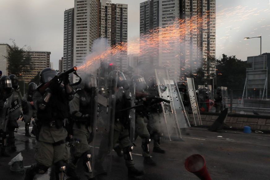 A riot police fires tear gas during a confrontation with protesters on Monday, Aug. 5, 2019. Droves of protesters filled public parks and squares in several Hong Kong districts on Monday in a general  ...
