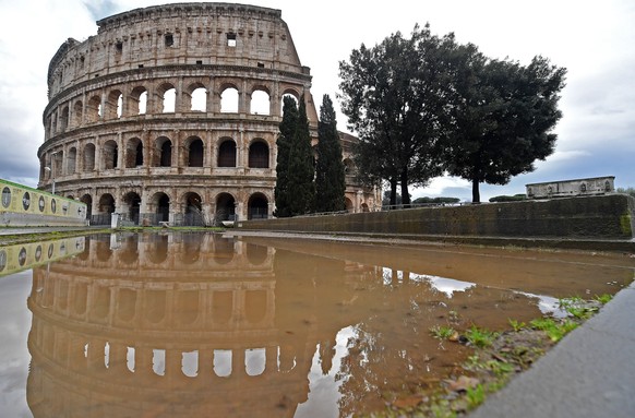 epa08920494 Puddles build up in the cobbled areas around the landmark ancient Colosseum during the heavy rains that hit Rome, Italy, 05 January 2021. The whole country is currently in the grip of a ba ...