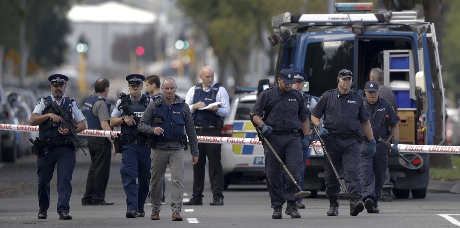 Police officers search the area near the Masjid Al Noor mosque, site of one of the mass shootings at two mosques in Christchurch, New Zealand, Saturday, March 16, 2019. (AP Photo/Mark Baker)