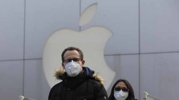 epaselect epa08186957 People wear masks as they walk past a closed Apple store at Sanlitun in Beijing, China, 02 February 2020. Apple announced the closure of its stores, corporate offices and contact ...