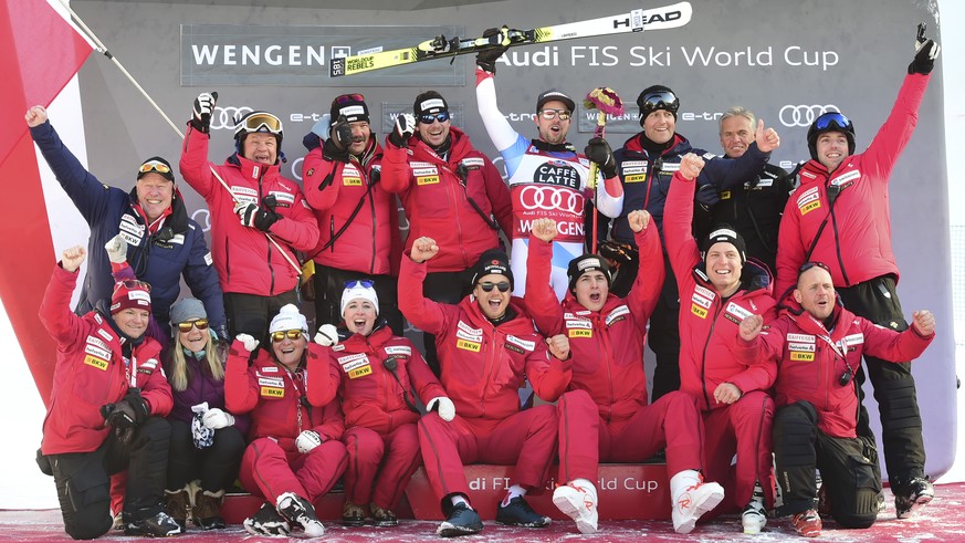 First placed Switzerland&#039;s Beat Feuz celebrates with his team on the podium of an alpine ski, World Cup men&#039;s downhill in Wengen, Switzerland, Saturday, Jan. 18, 2020. (AP Photo/Marco Tacca)