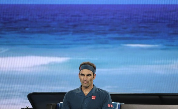 Switzerland&#039;s Roger Federer waits in his chair during a break in his third round match against United States&#039; Taylor Fritz at the Australian Open tennis championships in Melbourne, Australia ...