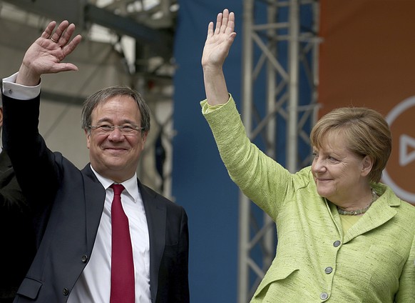 German chancellor Angela Merkel, right, and North Rhine-Westphalia top candidate of her Christian Democrats, Armin Laschet, wave to supporters at the last stage of the state election campaign in Aache ...