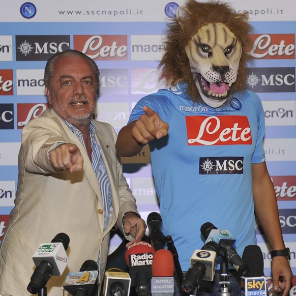 Swiss soccer player Goekhan Inler, right, wears a lion mask as a surprise for his supporters,while posing with Napoli&#039;s president Aurelio de Laurentiis, during his official presentation, in Naple ...
