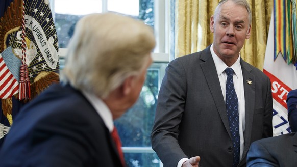 epa07233435 (FILE) - US President Donald J. Trump listens as US Secretary of the Interior Ryan Zinke (R) delivers remarks during a meeting with workers on &#039;Cutting the Red Tape, Unleashing Econom ...