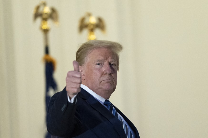 President Donald Trump gives thumbs up from the Blue Room Balcony upon returning to the White House Monday, Oct. 5, 2020, in Washington, after leaving Walter Reed National Military Medical Center, in  ...
