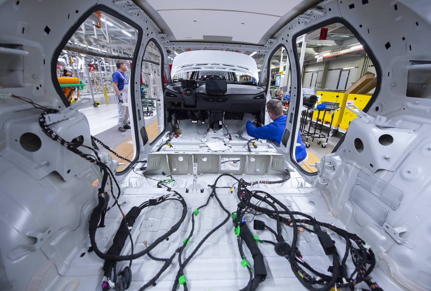 FILE - In this Tuesday, Feb. 25, 2020 file photo, a worker completes an electric car ID.3 body at the assembly line, during a press tour at the plant of the German manufacturer Volkswagen AG, VW, in Z ...