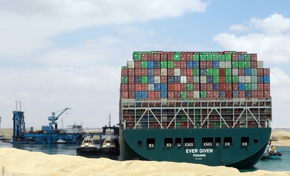 epaselect epa09098679 Egyptian tugboats try to pull out the Ever Given container ship stranded in the Suez Canal, Egypt, 26 March 2021. The large container ship Ever Given ran aground in the Suez Cana ...