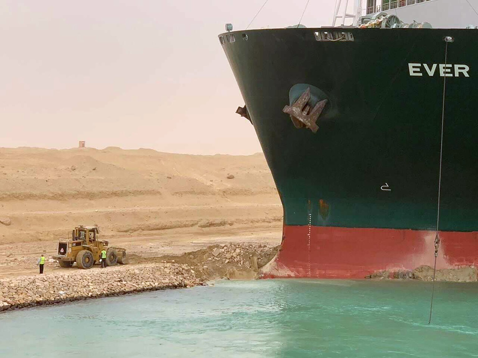 In this photo released by the Suez Canal Authority, a cargo ship, named the Ever Green, sits with its bow stuck into the wall Wednesday, March 24, 2021, after it turned sideways in Egypt���s Suez Cana ...