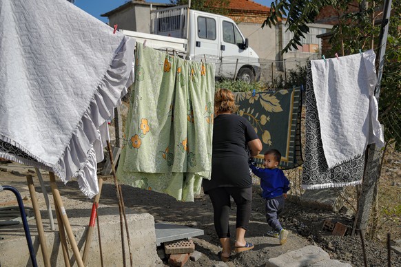 Azime Ali Topchu, 48, a Bulgarian Roma woman, walks with one of her nephews in a village on the outskirts of Burgas, Bulgaria, Monday, Sept. 28, 2020. Human rights activists and experts say local offi ...