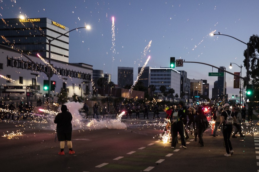 epa08455622 A flashbang explodes next to protesters as they face the police on Rodeo Drive during curfew as thousands of protesters take the street to demonstrate following the death of George Floyd,  ...