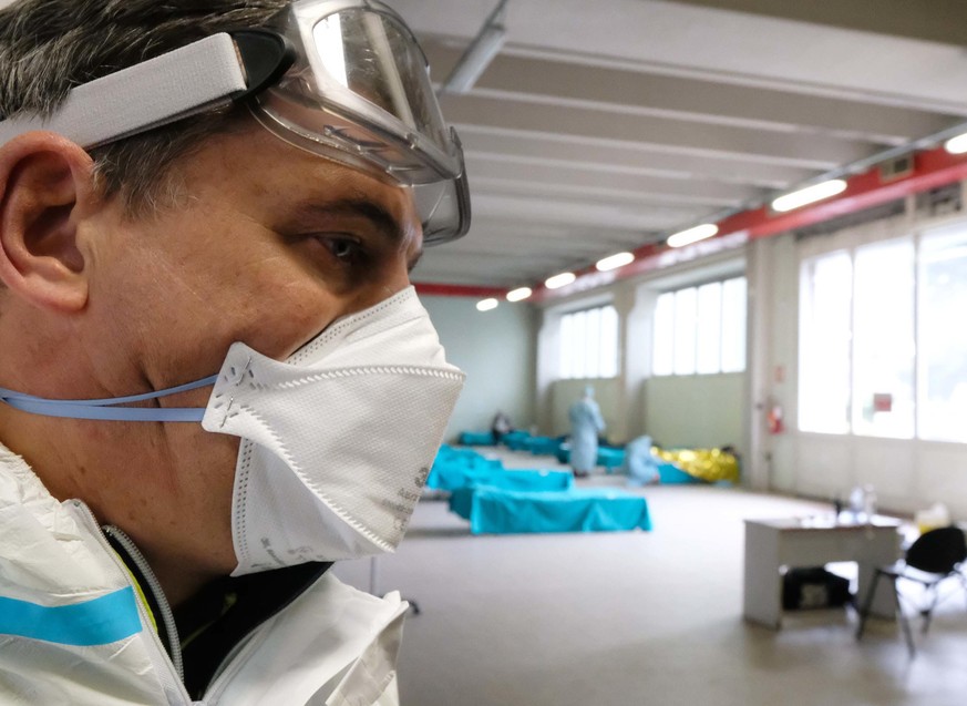 epa08280975 An health worker wearing a protecitve suit and a face mask at work in the facility on the outside of Brescia&#039; Hospital where people who have to undergo swabs for the Covid19 Coronavir ...