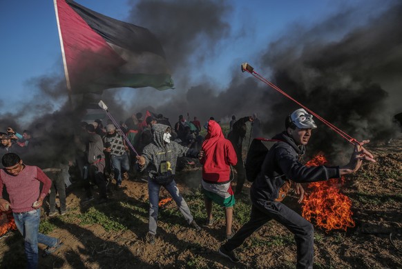 epa07423926 Palestinian protesters throw stones with slingshots during the clashes after protests near the border between Israel and Gaza Strip, east Gaza, 08 March 2019. According to reports, an 18-y ...