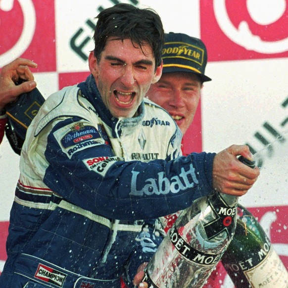 Formula One Japanese Grand Prix winner Damon Hill of Britain sprays champagne during the awarding ceremony at the Suzuka Circuit Sunday, Oct. 13, 1996. Behind Hill is third placer Mika Hakkinen of Fin ...