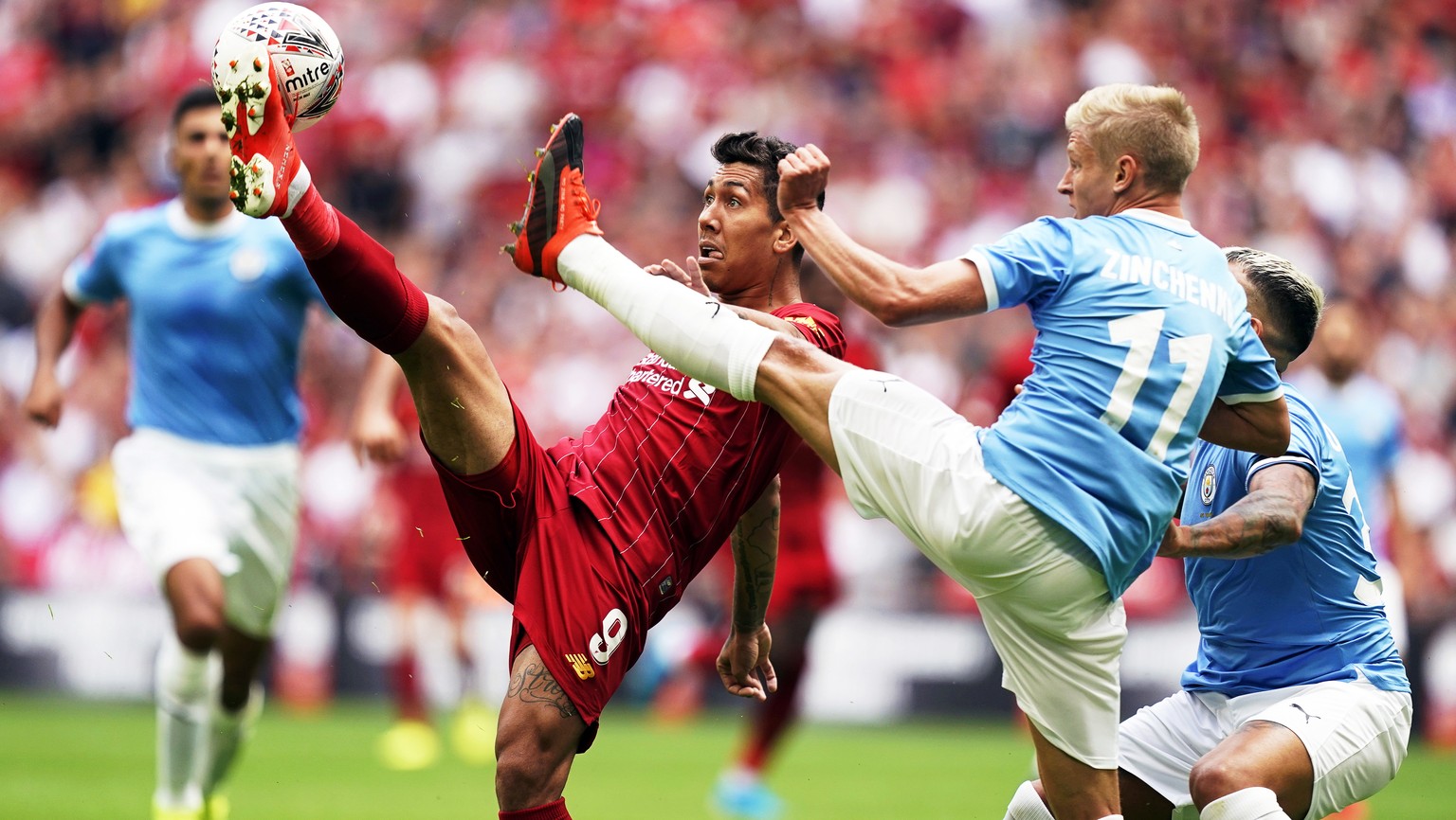 epa07756401 Liverpool&#039;s Roberto Firmino (L) in action against Manchester City&#039;s Oleksandr Zinchenko (2-R) during the FA Community Shield soccer match between Liverpool FC and and Manchester  ...