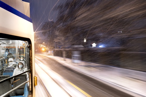Menschen mit Schutzmasken fahren im Tram 3 am Morgen frueh im Schneesturm am Dienstag 1. Dezember 2020 in Zuerich. (KEYSTONE/Gaetan Bally)
