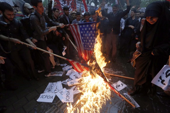 epa06722954 Iranians burn US and Israeli flags during an anti-US protest in front of the former US embassy in Tehran, Iran, 09 May 2018. Media reported that Iran said it will negotiate over the nuclea ...