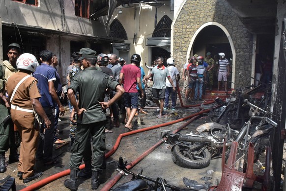 epa07518955 Locals and police gather at the Secon church Batticalova central road in Colombo, Sri Lanka, 21 April 2019. According to the news reports at least 138 people killed and over 400 injured in ...