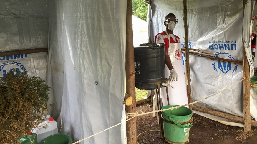 This photo taken Monday, June 10, 2019 and released by the International Rescue Committee (IRC), shows an Ebola screening checkpoint where people crossing from Congo go through foot and hand washing w ...