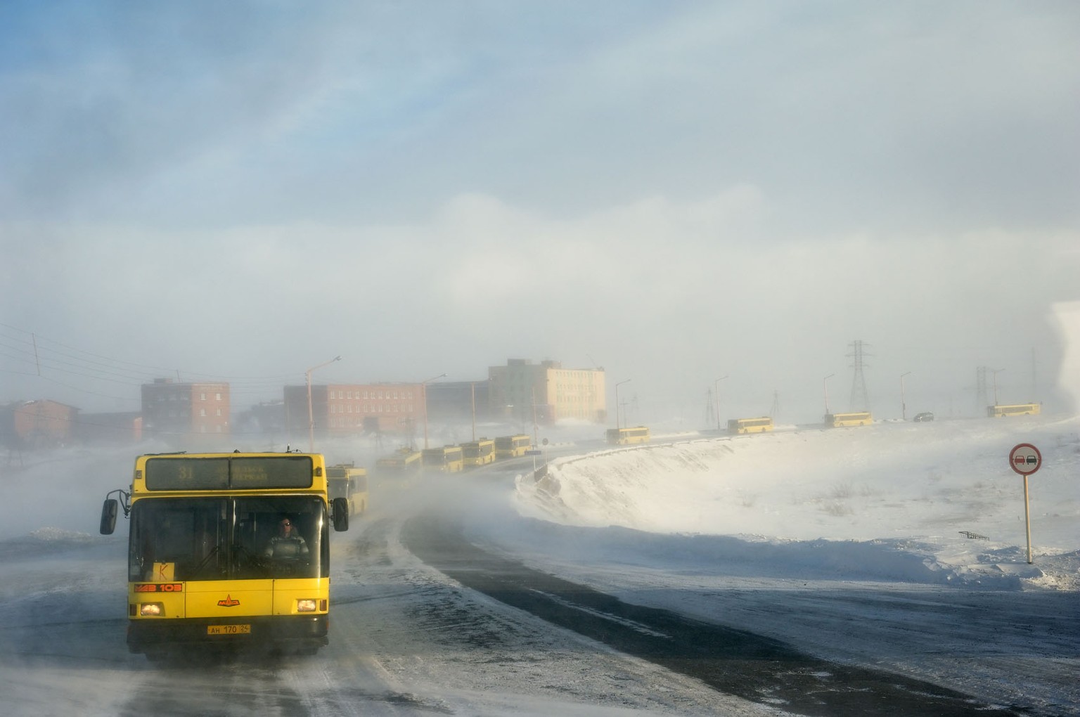 Lange Buskonvois bringen die Arbeiter in die drei grossen Fabriken, die Kohlegrube, die Nickelminen und Schmelzen und die Metallfabrik. Steigt ein Bus aus oder verunfallt er, werden die Insassen auf die anderen Busse verteilt. 