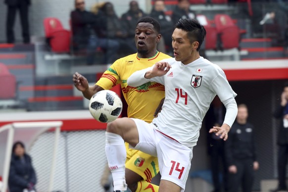 Japan&#039;s Yuya Kubo, foreground, fights for the ball with Mali&#039;s Balaye Dibassy during an international friendly soccer match between Japan and Mali at Maurice Dufrasne Stadium in Liege, Belgi ...